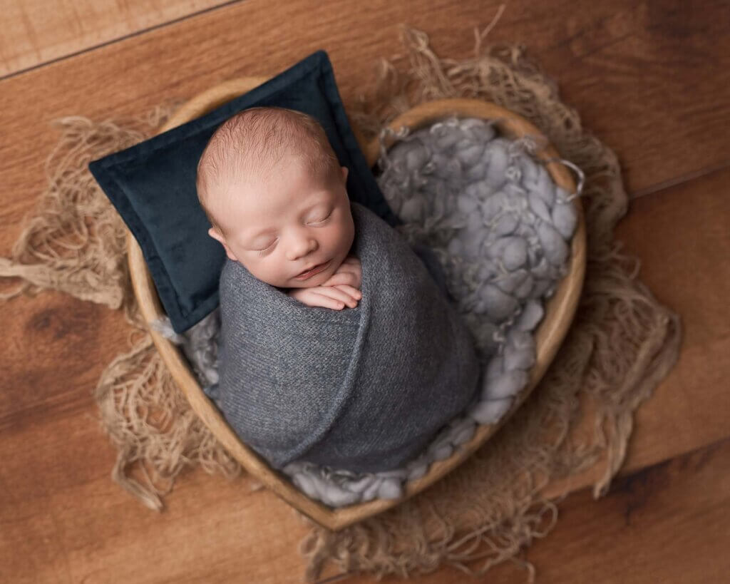 baby in grey in a bowl at a mini newborn photoshoot in Belfast