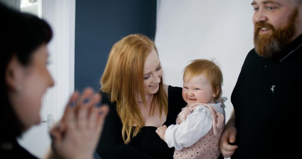 Behind the scenes picture of a family with a baby is the studio at a Cake Smash belfast photoshoot