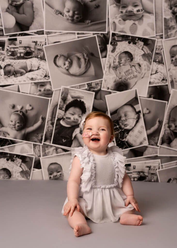 little girl in front of a colage of pictures of herself, in Cake Smash Belfast photoshoot