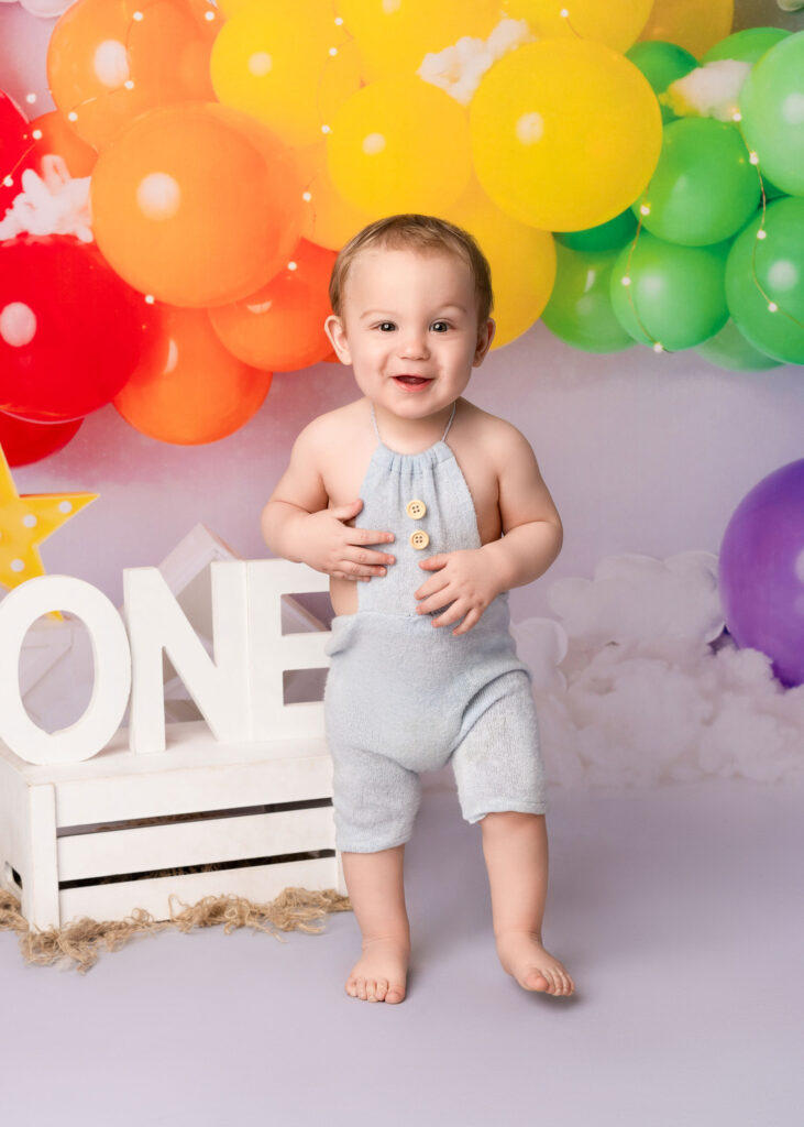 baby boy in blue dungarees at his Cake Smash Photoshoot Belfast